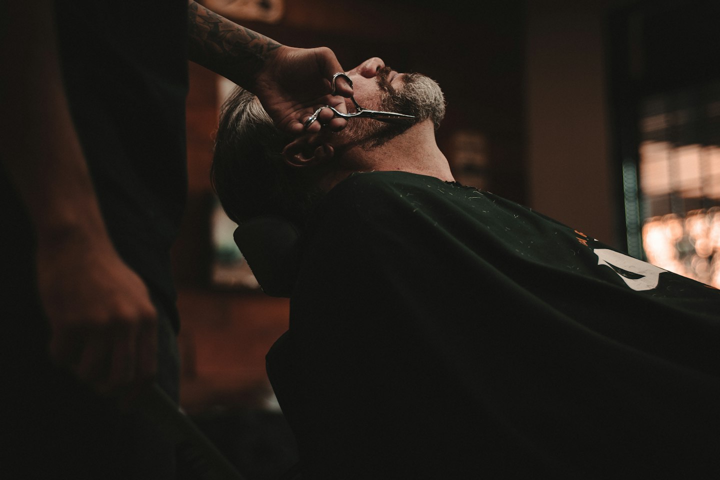 Barbeiro fazendo um corte com atenção aos detalhes